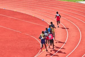 Track runners competing in a sprint race on the athletics track at Paloma Mizuho Stadium