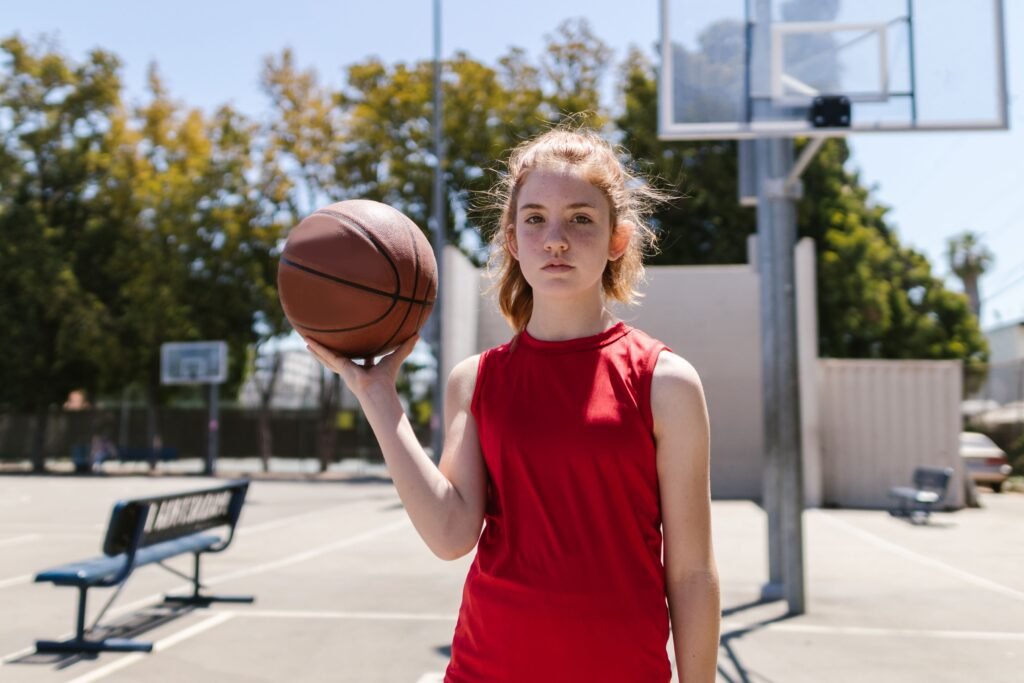 Young female athletes training on a basketball court to represent Canadian women's sports. 