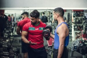 A personal trainer guiding a beginner through a weight-loss workout at the gym.